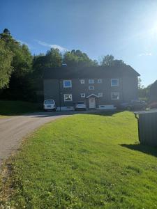 a large house with two cars parked in the driveway at Central functional apartment with short distance to everything in Sandefjord