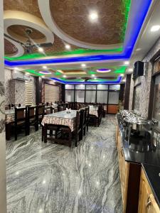 a restaurant with a dining room with tables and chairs at Hotel Shuhrah-I-Afaq - Near Srinagar Airport in Baghwānpur