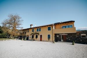 a large yellow building with a large driveway at BRIC Wine & Relax in Vogrsko