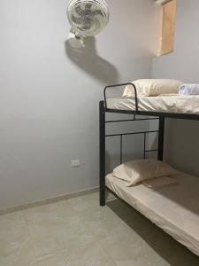 a room with two bunk beds and a fan at Tres Palmas Apartamento in Carmen de Apicalá