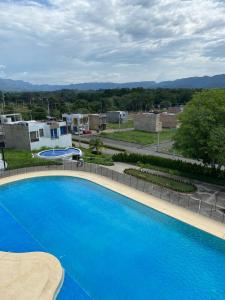 a large blue swimming pool in a yard at Tres Palmas Apartamento in Carmen de Apicalá