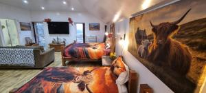 a bedroom with two beds and a large painting on the wall at Windsor Cottage on The Big "W" Ranch in Nether Wasdale