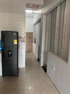 a hallway with a refrigerator in a room at Tres Palmas Apartamento in Carmen de Apicalá