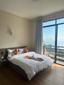 a bedroom with a bed and a large window at The Himalayan Ridge in Kathmandu