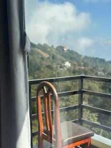 a chair sitting on a balcony looking out the window at The Himalayan Ridge in Kathmandu +23 photos