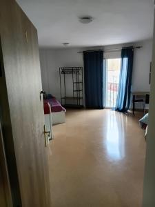 a room with a bed and a room with blue curtains at EMMI Guesthouse in Alicante