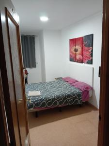 a bedroom with a bed and a painting on the wall at EMMI Guesthouse in Alicante
