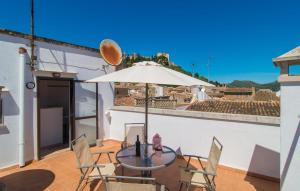 a table and chairs with an umbrella on a balcony at Roser De Arta in Artá