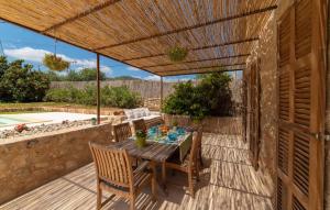 a wooden table and chairs under a wooden pergola at Son Cullera Petit in Son Servera