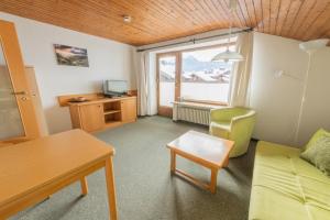 a living room with a couch and a table and a window at T13 Ferienwohnungen Schenk in Oberstdorf