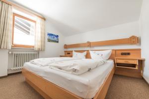 a bedroom with a large bed with white sheets at T13 Ferienwohnungen Schenk in Oberstdorf