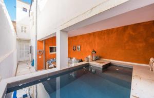 a swimming pool in a house with an orange wall at Ca Sa Batlessa in Artá