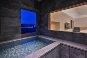 a large bathroom with a tub with a window at Ureshino Onsen Yusyuku Sarayama in Ureshino