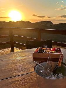 a table with a box of wine and a glass at Fabulosas da Serra in Monte das Gameleiras