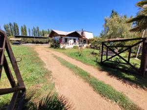 a dirt road in front of a house with a fence at Casa Berries in Colbún +29 photos