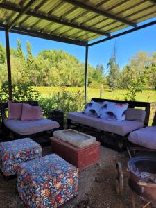 a group of beds and ottomans under a tent at Casa Berries in Colbún