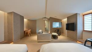 a room with a bed and a tv and a couch at Ureshino Onsen Yusyuku Sarayama in Ureshino +23 photos