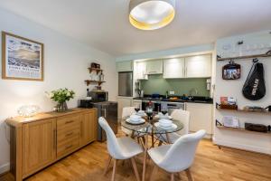 a kitchen with a table and chairs in a room at Calder apartment Raven Wing in Fort Augustus