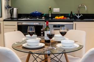 a table with two glasses of wine on it at Calder apartment Raven Wing in Fort Augustus