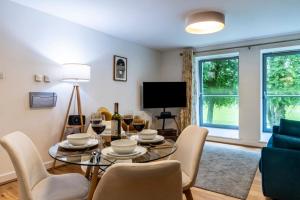 a living room with a table and chairs and a tv at Calder apartment Raven Wing in Fort Augustus