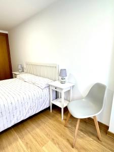 a bedroom with a bed and a table and a chair at Alice House in Miño +4 photos