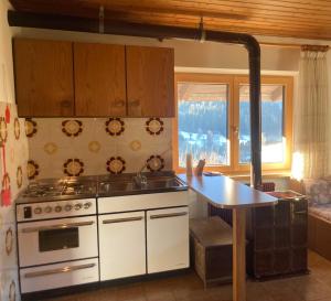 a kitchen with a stove and a sink and a table at Casa Defrancesco in Panchià +13 photos