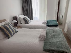 a bedroom with two beds with towels on them at Seaview West Coast - Exceptional - 2 Bedrooms Sleeps 5 -Stunning Sea Views - 500 metres to Beach in Bournemouth
