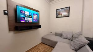 a living room with a couch and a flat screen tv at Estudios Hotel Colonial in Escárcega