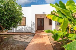 a white house with a door and some plants at Villa Beso in San Antonio