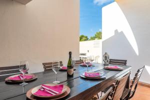 a table with a bottle of wine and glasses at Villa Beso in San Antonio
