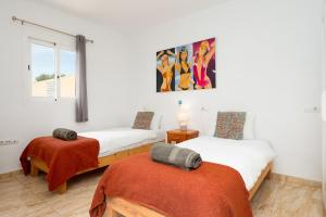 a bedroom with two beds and a painting on the wall at Villa Beso in San Antonio +24 photos