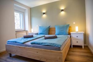 a bedroom with a large wooden bed with blue pillows at Ferienhaus zum Brauneberg in Klotten