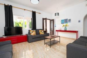 a living room with two couches and a flat screen tv at Villa Beso in San Antonio