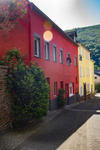 a red and yellow building on the side of a street at Ferienhaus zum Brauneberg in Klotten