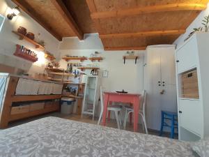 a kitchen with a table and a red table in a room at A tiny sea home in the wilderness in Vis