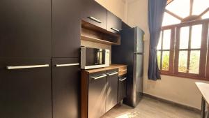 a kitchen with a refrigerator and a microwave at Estudios Hotel Colonial in Escárcega