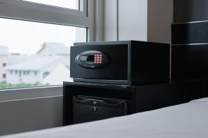 a speaker sitting on top of a black box next to a window at Hotel 81 Changi in Singapore