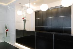 a black and white lobby with two lights and flowers at Hotel 81 Changi in Singapore