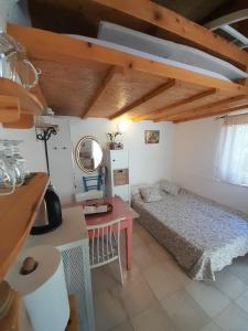 a small bedroom with a bed and a desk at A tiny sea home in the wilderness in Vis