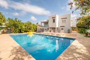 a swimming pool in front of a house at Villa Sunset - San Antonio Bay in Cala de Bou