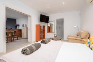 a bedroom with a white bed and a living room at Villa Sunset - San Antonio Bay in Cala de Bou +44 photos