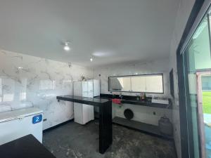 a room with a black desk and a tv on a wall at Mansão Xodó in Marataizes +2 photos