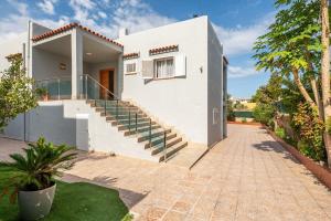 a white house with stairs and a walkway at Villa Sunset - San Antonio Bay in Cala de Bou