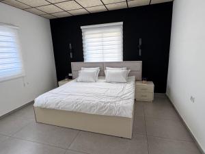 a bedroom with a large bed with white sheets and pillows at Country breeze park in Majdal Shams
