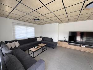 a living room with a couch and a flat screen tv at Country breeze park in Majdal Shams