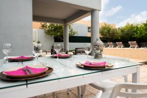 a table with glasses and napkins on a patio at Villa Sunset - San Antonio Bay in Cala de Bou