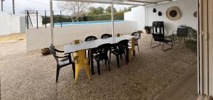 a table and chairs in a patio with a pool at Casa rural Macondo in Trujillanos