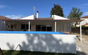 a house with a swimming pool in front of it at Casa rural Macondo in Trujillanos