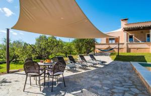 a patio with a table and chairs under a large umbrella at S'oratge in Artá +44 photos