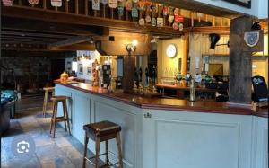 a bar in a pub with a counter and stools at The Coldstreamer Inn in Penzance